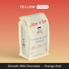A bag of Mom 'n 'em Coffee Lights Out Decaf on a red-orange gradient background.