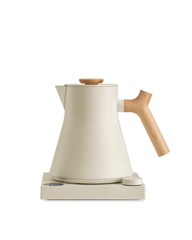 Fellow Corvo EKG Electric Kettle in cream with wood handle and lid, on matching base.