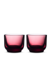 Two Pirch Espresso Glasses by Fellow in transparent dark pink sit side by side on a light background.