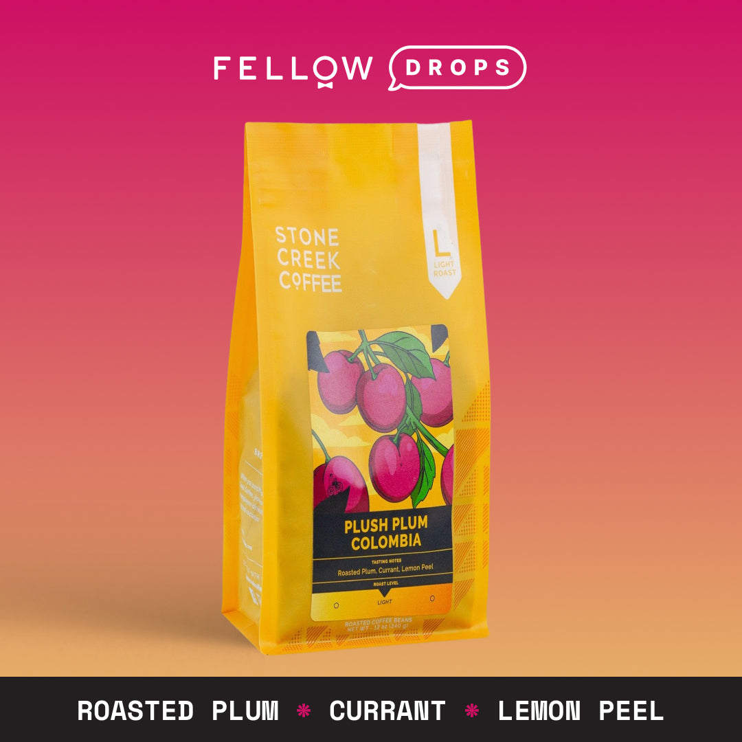 Yellow bag of Stone Creek Coffee Plush Plum Colombia light roast on a pink background.