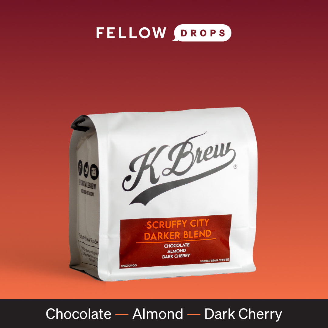 K Brew Scruffy City Darker Roast coffee bag on a red gradient background.