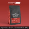 A red and black Immigrant Culture Olé coffee bag with medium roast Colombian coffee.