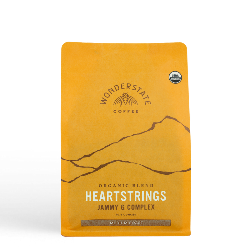 Yellow Wonderstate Coffee Heartstrings bag with a mountain illustration and organic seal.