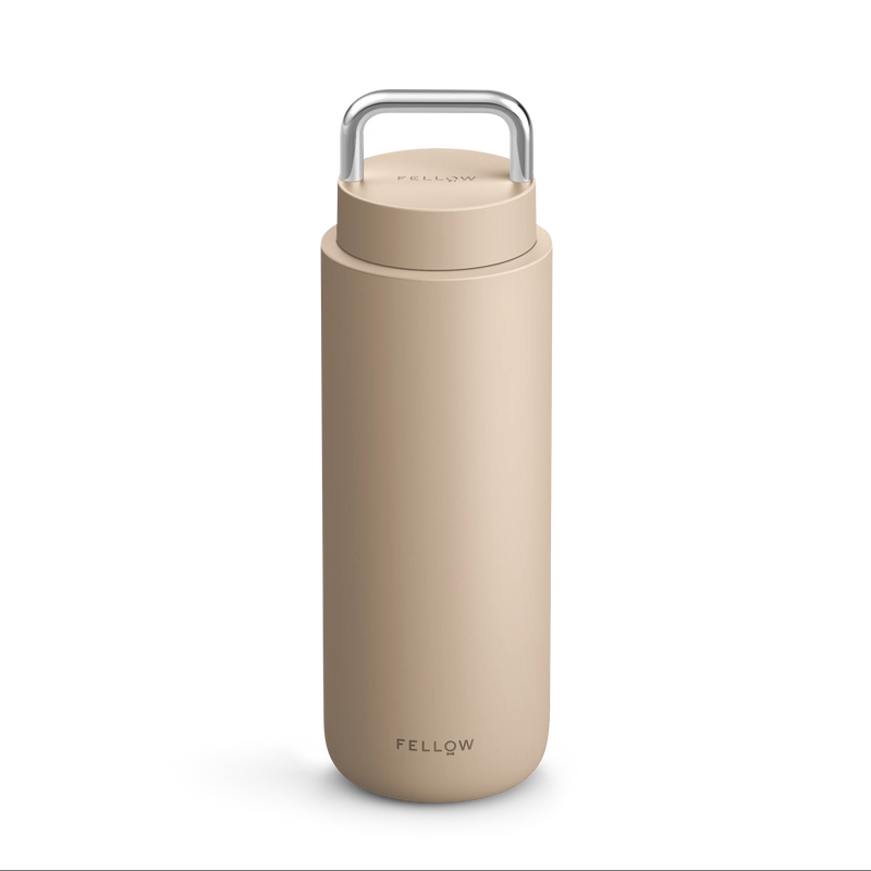 Beige Fellow Carter Carry Travel Mug with metal handle and "Fellow" on the front.