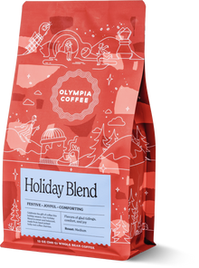 Red Olympia Holiday Blend coffee bag with white winter illustrations and label details.