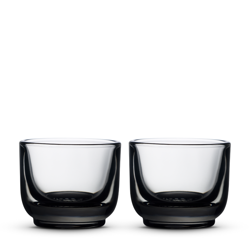 Two Fellow Pirch espresso glasses in smoke color on a plain white background.