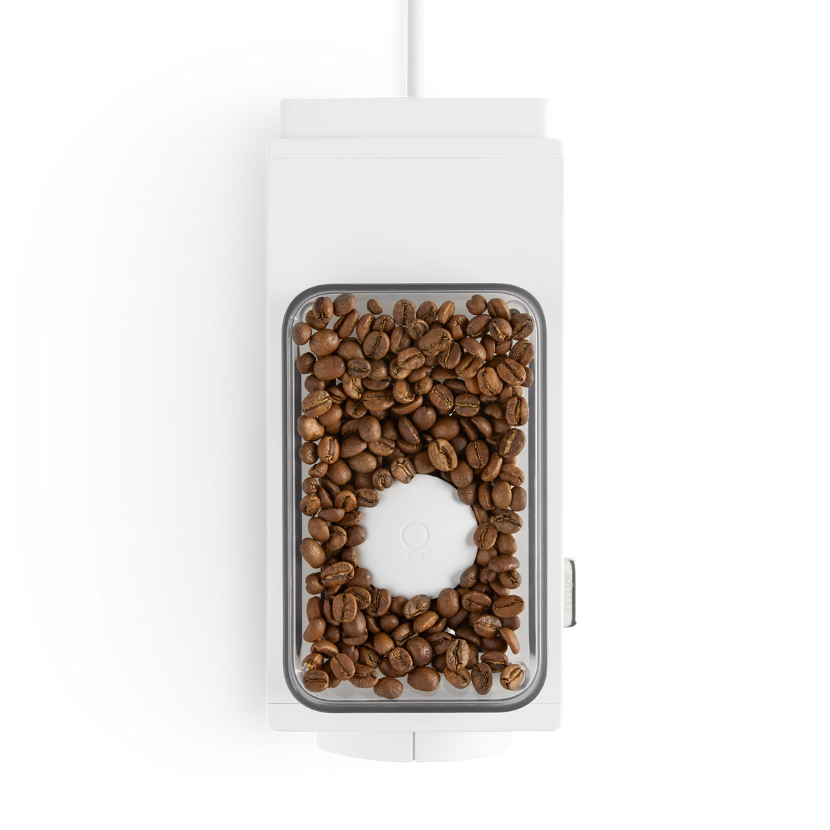 Top view of a white coffee grinder with whole coffee beans—perfect for any home barista.