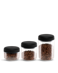 Fellow Atmos Vacuum Canister 3 Pack stores coffee beans in clear jars with black lids.