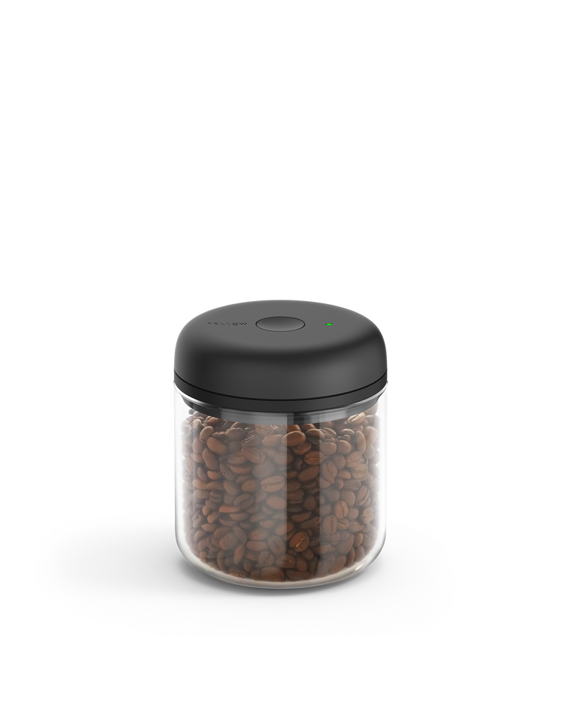 Fellow Atmos Vacuum Canister with black lid, storing coffee beans on a white background.