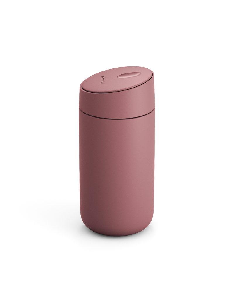 The Fellow Carter Slide Mug, a pink reusable travel cup with a rounded lid, on white background.