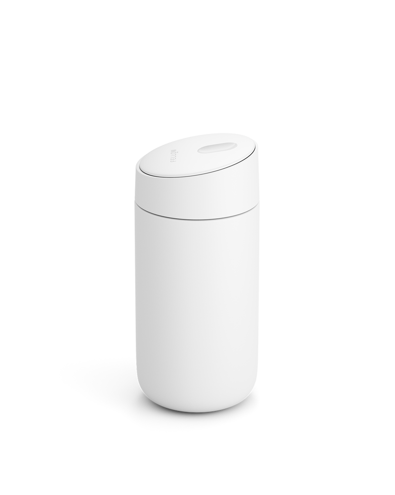 The Fellow Carter Slide Mug is a minimalist white cylinder with a rounded, slightly tilted lid.