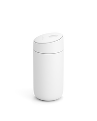 The Fellow Carter Slide Mug is a minimalist white cylinder with a rounded, slightly tilted lid. - media thumbnail