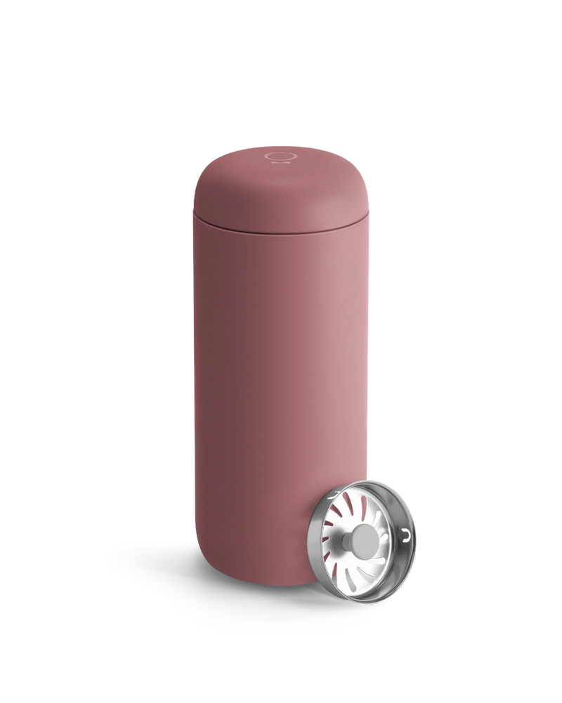 Fellow Carter Move Mug—matte pink with metal strainer, ideal travel mug on white background.