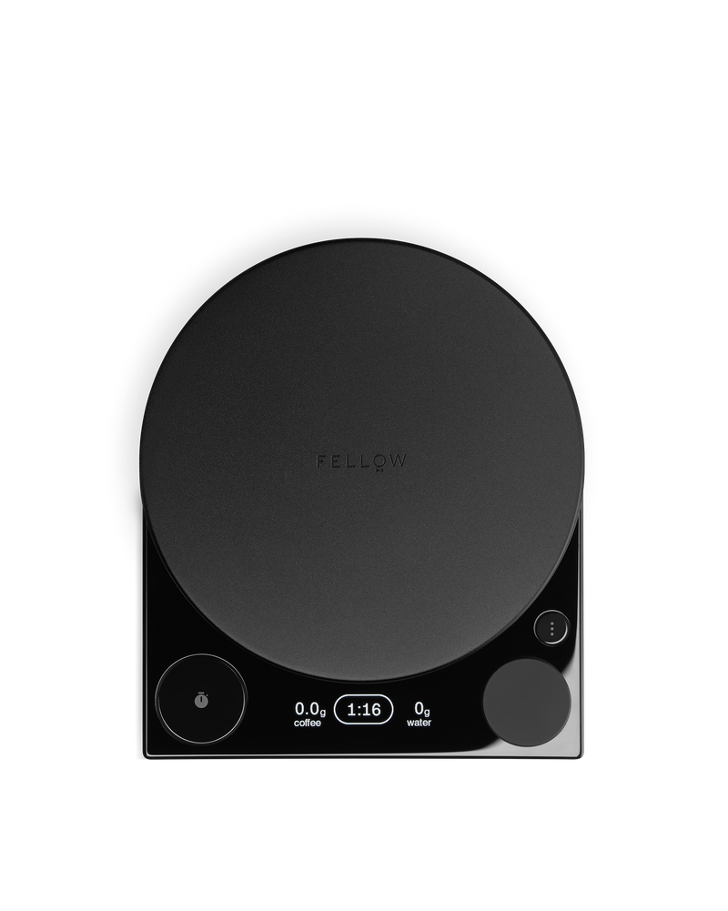 The Fellow Tally™ Pro Studio is a black coffee scale with a round platform and lit digital display.