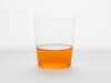 A clear glass half-filled with Song Tea & Ceramics Carrot tea on a white background.